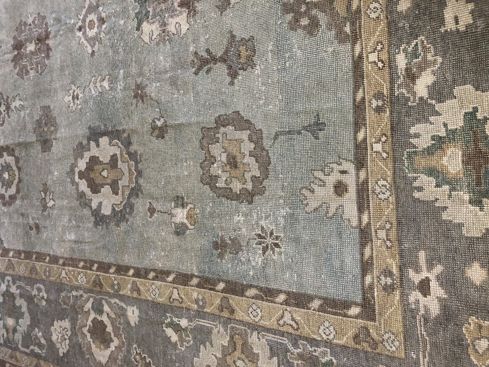Detail of an Oushak rug showing loose knotting and muted natural dyes